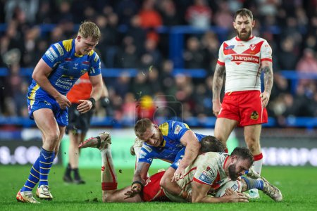 Photo for Alex Walmsley of St. Helens is tackled by Mikolaj Oledzki of Leeds Rhinos  and Andy Ackers of Leeds Rhinos during the Betfred Super League Round 5 match Leeds Rhinos vs St Helens at Headingley Stadium, Leeds, United Kingdom, 15th March 202 - Royalty Free Image