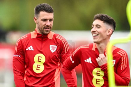 Photo for Aaron Ramsey and Harry Wilson of Wales share a joke during warms up ahead of the Wales open training session at Vale Resort Training complex, Hensol, United Kingdom, 20th March 2024 - Royalty Free Image