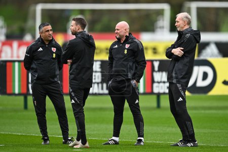 Photo for Rob Page Manager of Wales chats to his staff during warms up ahead of the Wales open training session at Vale Resort Training complex, Hensol, United Kingdom, 20th March 2024 - Royalty Free Image