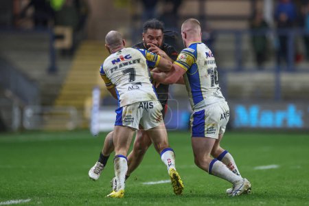 Photo for Konrad Hurrell of St. Helens is tackled by Matt Frawley of Leeds Rhinos and Tom Holroyd of Leeds Rhinos during the Betfred Challenge Cup Sixth Round match Leeds Rhinos vs St Helens at Headingley Stadium, Leeds, United Kingdom, 22nd March 202 - Royalty Free Image