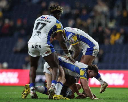 Photo for Matty Lees of St. Helens is up ended by Cameron Smith of Leeds Rhinos and Andy Ackers of Leeds Rhinos giving St Helens a penalty during the Betfred Challenge Cup Sixth Round match Leeds Rhinos vs St Helens at Headingley Stadium, Leeds, United Kingdom - Royalty Free Image