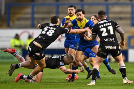 Photo for Toby King of Warrington Wolves is tackled by Jarred Bassett of London Broncos and Jack Hughes of London Broncos during the Betfred Challenge Cup Sixth Round match Warrington Wolves vs London Broncos at Halliwell Jones Stadium, Warrington, United King - Royalty Free Image