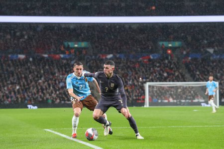 Photo for Phil Foden of England holds off Timothy Castagne of Belgium during the International Friendly match England vs Belgium at Wembley Stadium, London, United Kingdom, 26th March 202 - Royalty Free Image