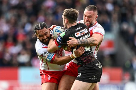 Photo for Jake Wardle of Wigan Warriors is tackled by Konrad Hurrell of St. Helens and Curtis Sironen of St. Helens during the Betfred Super League Round 6 match St Helens vs Wigan Warriors at Totally Wicked Stadium, St Helens, United Kingdom, 29th March 202 - Royalty Free Image