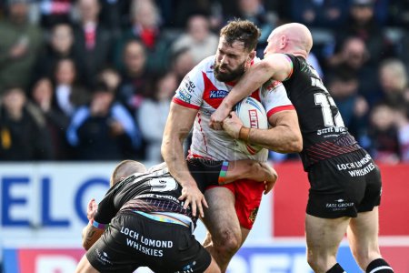 Photo for Alex Walmsley of St. Helens is tackled by Liam Farrell of Wigan Warriors and Brad ONeill of Wigan Warriors during the Betfred Super League Round 6 match St Helens vs Wigan Warriors at Totally Wicked Stadium, St Helens, United Kingdom, 29th March 2024 - Royalty Free Image
