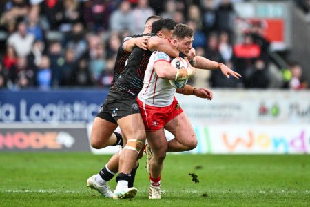 Photo for Morgan Knowles of St. Helens is tackled by Patrick Mago of Wigan Warriors during the Betfred Super League Round 6 match St Helens vs Wigan Warriors at Totally Wicked Stadium, St Helens, United Kingdom, 29th March 202 - Royalty Free Image