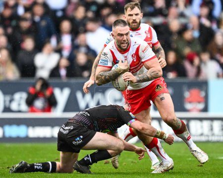Photo for Curtis Sironen of St. Helens breaks the tackle by Alex Smith of Wigan Warriors during the Betfred Super League Round 6 match St Helens vs Wigan Warriors at Totally Wicked Stadium, St Helens, United Kingdom, 29th March 202 - Royalty Free Image