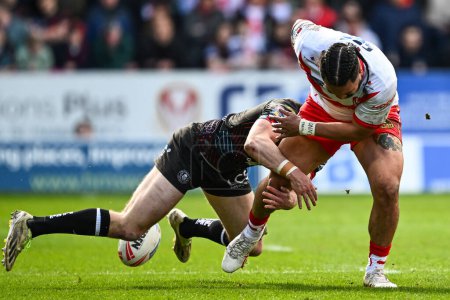 Photo for Konrad Hurrell of St. Helens has the ball stripped in the tackle by Jake Wardle of Wigan Warriors during the Betfred Super League Round 6 match St Helens vs Wigan Warriors at Totally Wicked Stadium, St Helens, United Kingdom, 29th March 202 - Royalty Free Image