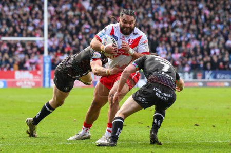 Photo for Konrad Hurrell of St. Helens is tackled by Alex Smith of Wigan Warriors  and Jake Wardle of Wigan Warriors during the Betfred Super League Round 6 match St Helens vs Wigan Warriors at Totally Wicked Stadium, St Helens, United Kingdom, 29th March 202 - Royalty Free Image