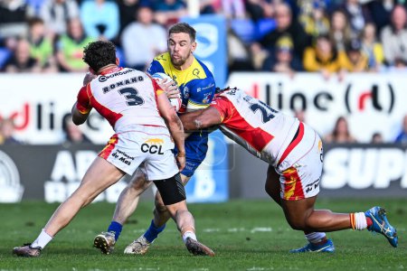 Photo for Matt Dufty of Warrington Wolves is tackled by Chris Satae of Catalan Dragons and Arthur Romano of Catalan Dragons during the Betfred Super League match Warrington Wolves vs Catalans Dragons at Halliwell Jones Stadium, Warrington, United Kingdom, 30th - Royalty Free Image
