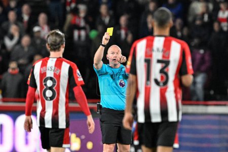 Photo for Referee Simon Hooper gives a yellow card to Mathias Zanka Jrgensen of Brentford during the Premier League match Brentford vs Manchester United at The Gtech Community Stadium, London, United Kingdom, 30th March 2024 - Royalty Free Image