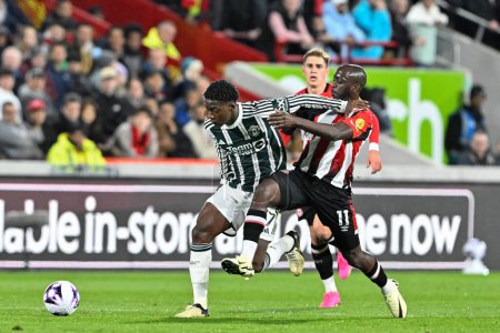 Photo for Kobbie Mainoo of Manchester United holds Yoane Wissa of Brentford off the ball during the Premier League match Brentford vs Manchester United at The Gtech Community Stadium, London, United Kingdom, 30th March 202 - Royalty Free Image