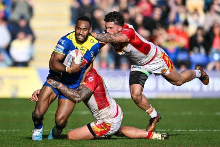 Photo for Rodrick Tai of Warrington Wolves is tackled by Tariq Sims of Catalan Dragons and Arthur Romano of Catalan Dragons during the Betfred Super League match Warrington Wolves vs Catalans Dragons at Halliwell Jones Stadium, Warrington, United Kingdom, 30th - Royalty Free Image