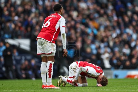 Foto de Martin degaard de Arsenal cae con una lesión durante el partido de la Premier League Manchester City vs Arsenal en el Etihad Stadium, Manchester, Reino Unido, 31 de marzo de 2024 - Imagen libre de derechos