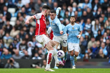 Photo for Declan Rice of Arsenal is tackled by Phil Foden of Manchester City during the Premier League match Manchester City vs Arsenal at Etihad Stadium, Manchester, United Kingdom, 31st March 202 - Royalty Free Image