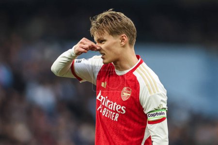 Photo for Martin degaard of Arsenal hold his nose during the Premier League match Manchester City vs Arsenal at Etihad Stadium, Manchester, United Kingdom, 31st March 2024 - Royalty Free Image