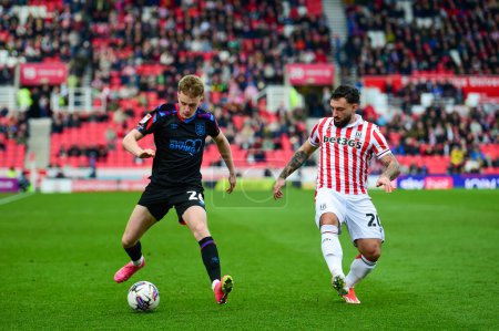 Photo for Pat Jones of Huddersfield Town challenged by Sead Hakabanovi of Stoke City during the Sky Bet Championship match Stoke City vs Huddersfield Town at Bet365 Stadium, Stoke-on-Trent, United Kingdom, 1st April 2024 - Royalty Free Image