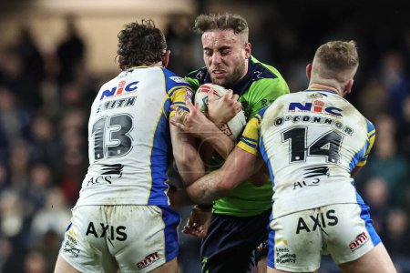 Photo for James Harrison of Warrington Wolves is tackled by Cameron Smith of Leeds Rhinos and Jarrod OConnor of Leeds Rhinos during the Betfred Super League Round 7 match Leeds Rhinos vs Warrington Wolves at Headingley Stadium, Leeds, United Kingdom - Royalty Free Image