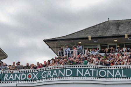 Photo for Racegoers look on as the 16:00 Randox Grand National Handicap Chase gets under way  during the Randox Grand National Day 2024 at Aintree Racecourse, Liverpool, United Kingdom, 13th April 202 - Royalty Free Image