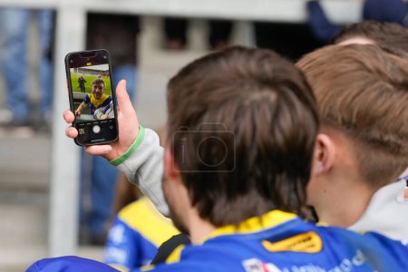 Photo for Adam Holroyd of Warrington Wolves poses for a selfie with a fan after the Betfred Challenge Cup Quarter Final match St Helens vs Warrington Wolves at Totally Wicked Stadium, St Helens, United Kingdom, 14th April 202 - Royalty Free Image