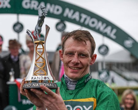 Photo for Paul Townend lifts the winner trophy as he wins the 16:00 Randox Grand National Handicap Chase on I Am Maximus during the Randox Grand National Day 2024 at Aintree Racecourse, Liverpool, United Kingdom, 13th April 202 - Royalty Free Image