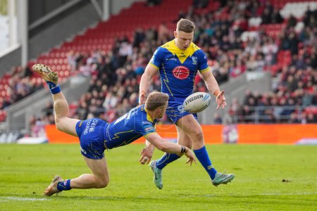 Photo for Matt Dufty of Warrington Wolves offloads to George Williams of Warrington Wolves during the Betfred Challenge Cup Quarter Final match St Helens vs Warrington Wolves at Totally Wicked Stadium, St Helens, United Kingdom, 14th April 202 - Royalty Free Image