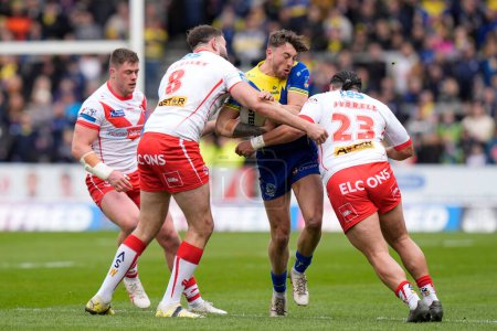 Photo for Matty Ashton of Warrington Wolves is tackled by Konrad Hurrell of St. Helens and Alex Walmsley of St. Helens during the Betfred Challenge Cup Quarter Final match St Helens vs Warrington Wolves at Totally Wicked Stadium, St Helens, United Kingdom, 14t - Royalty Free Image