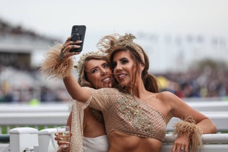 Téléchargez les photos : Les coureurs profitent de l'atmosphère lors de la Journée nationale des dames Le Randox 2024 à l'hippodrome d'Aintree, Liverpool, Royaume-Uni, 12 avril 202 - en image libre de droit