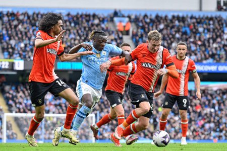 Photo for Alfie Doughty of Luton Town battles for the ball with Jrmy Doku of Manchester City, during the Premier League match Manchester City vs Luton Town at Etihad Stadium, Manchester, United Kingdom, 13th April 2024 - Royalty Free Image