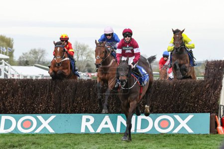 Photo for Conflated ridden by Jack Kennedy jumps the fence first in the first lap during the The Randox Grand National 2024 Ladies Day at Aintree Racecourse, Liverpool, United Kingdom, 12th April 202 - Royalty Free Image