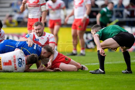 Photo for Referee Jack Smith checks for grounding as James Harrison of Warrington Wolves dives over the line to score a try during the Betfred Challenge Cup Quarter Final match St Helens vs Warrington Wolves at Totally Wicked Stadium, St Helens, United Kingdom - Royalty Free Image