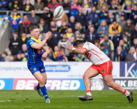Photo for George Williams of Warrington Wolves flicks the ball over Konrad Hurrell of St. Helens during the Betfred Challenge Cup Quarter Final match St Helens vs Warrington Wolves at Totally Wicked Stadium, St Helens, United Kingdom, 14th April 202 - Royalty Free Image
