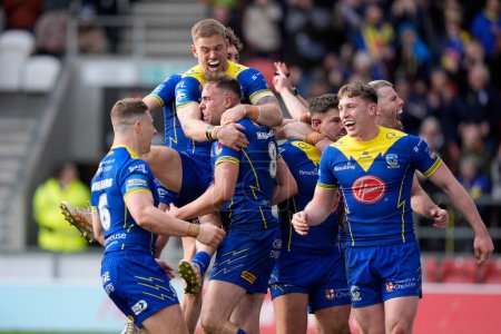 Photo for Matt Dufty of Warrington Wolves celebrates with try scorer James Harrison of Warrington Wolves during the Betfred Challenge Cup Quarter Final match St Helens vs Warrington Wolves at Totally Wicked Stadium, St Helens, United Kingdom, 14th April 202 - Royalty Free Image