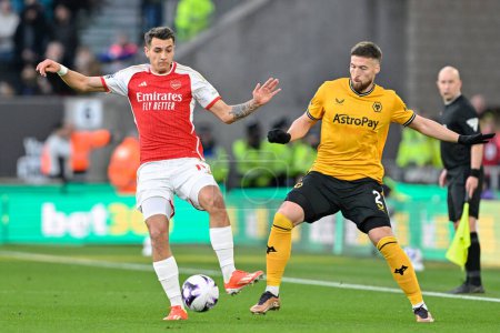 Photo for Jakub Kiwior of Arsenal and Matt Doherty of Wolverhampton Wanderers battle for the ball, during the Premier League match Wolverhampton Wanderers vs Arsenal at Molineux, Wolverhampton, United Kingdom, 20th April 202 - Royalty Free Image