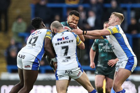 Photo for Esan Marsters of Huddersfield Giants is tackled by Justin Sangare of Leeds Rhinos and Matt Frawley of Leeds Rhinos during the Betfred Super League Round 8 match Leeds Rhinos vs Huddersfield Giants at Headingley Stadium, Leeds, United Kingdom, 19th Ap - Royalty Free Image