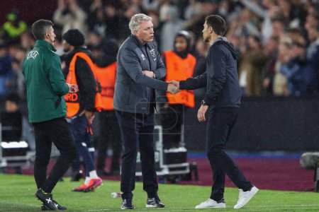 Photo for David Moyes manager of West Ham United and Xabi Alonso manager of Bayer Leverkusen shake hands after the UEFA Europa League Quarter-Final match West Ham United vs Bayer 04 Leverkusen at London Stadium, London, United Kingdom, 18th April 202 - Royalty Free Image