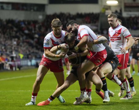 Photo for Tommy Makinson of St. Helens and Konrad Hurrell of St. Helens combine to tackle Logan Moy of Hull FC during the Betfred Super League  Round 8 match St Helens vs Hull FC at Totally Wicked Stadium, St Helens, United Kingdom, 19th April 202 - Royalty Free Image