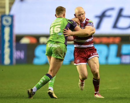 Photo for Liam Farrell of Wigan Warriors is tackled by Rowan Milnes of Castleford Tigers during the Betfred Super League Round 8 match Wigan Warriors vs Castleford Tigers at DW Stadium, Wigan, United Kingdom, 19th April 202 - Royalty Free Image