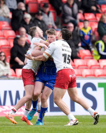 Photo for Matty Nicholson of Warrington Wolves is held by Ryan Brierley of Salford Red Devils and Shane Wright of Salford Red Devils during the Betfred Super League Round 9 match Salford Red Devils vs Warrington Wolves at Salford Community Stadium, Eccles, Uni - Royalty Free Image