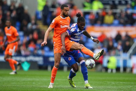 Photo for CJ Hamilton of Blackpool tackles Jeriel Dorsett of Reading during the Sky Bet League 1 match Reading vs Blackpool at Select Car Leasing Stadium, Reading, United Kingdom, 27th April 202 - Royalty Free Image