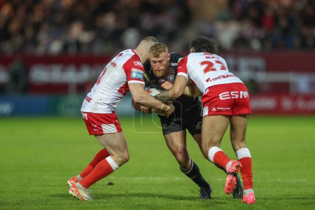 Photo for Luke Thompson of Wigan Warriors is tackled by James Batchelor of Hull KR and Tyrone May of Hull KR during the Betfred Super League Round 9 match Hull KR vs Wigan Warriors at Sewell Group Craven Park, Kingston upon Hull, United Kingdom, 26th April 202 - Royalty Free Image