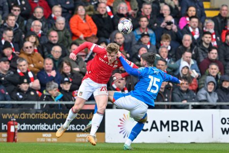Photo for Andy Cannon of Wrexham and Ethan Pye of Stockport County  battle for the ball, during the Sky Bet League 2 match Wrexham vs Stockport County at SToK Cae Ras, Wrexham, United Kingdom, 27th April 202 - Royalty Free Image
