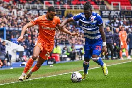Photo for CJ Hamilton of Blackpool battles for the ball with Jeriel Dorsett of Reading during the Sky Bet League 1 match Reading vs Blackpool at Select Car Leasing Stadium, Reading, United Kingdom, 27th April 202 - Royalty Free Image