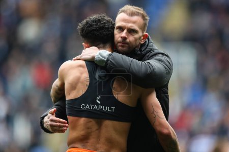 Photo for Jordan Rhodes of Blackpool embraces Jordan Lawrence-Gabriel of Blackpool after the Sky Bet League 1 match Reading vs Blackpool at Select Car Leasing Stadium, Reading, United Kingdom, 27th April 202 - Royalty Free Image