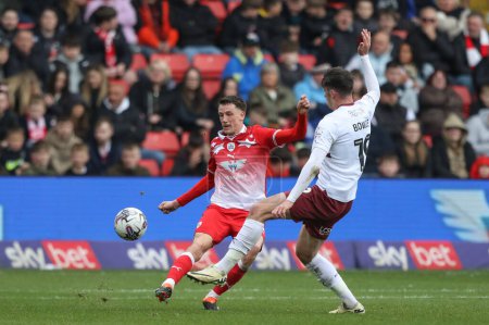 Photo for Mal de Gevigney of Barnsley clears the ball pressured by Kieron Bowie of Northampton Town during the Sky Bet League 1 match Barnsley vs Northampton Town at Oakwell, Barnsley, United Kingdom, 27th April 2023 - Royalty Free Image