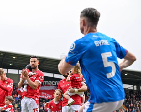 Photo for Eoghan O'Connell of Wrexham claps Stockport County players onto the pitch as part of the guard of honer ahead of the Sky Bet League 2 match Wrexham vs Stockport County at SToK Cae Ras, Wrexham, United Kingdom, 27th April 202 - Royalty Free Image