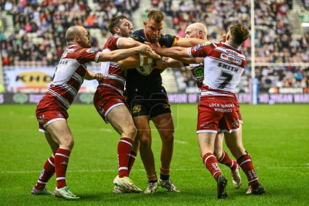 Photo for Mike McMeeken of Catalan Dragons tackled by Liam Farrell, Jake Wardle, Liam Marshall and Harry Smith of Wigan Warriors during Betfred Super League Round 10 match Wigan Warriors vs Catalans Dragons at DW Stadium, Wigan, United Kingdom, 2nd May 2024 - Royalty Free Image