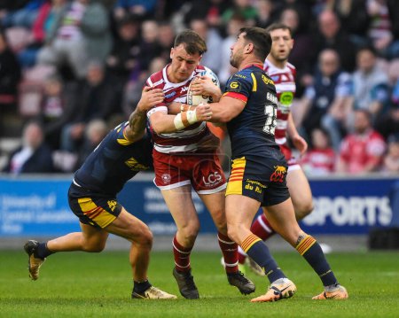 Photo for Harry Smith of Wigan Warriors is tackled by Ben Garcia of Catalan Dragons and Tariq Sims of Catalan Dragons during the Betfred Super League Round 10 match Wigan Warriors vs Catalans Dragons at DW Stadium, Wigan, United Kingdom, 2nd May 2024 - Royalty Free Image