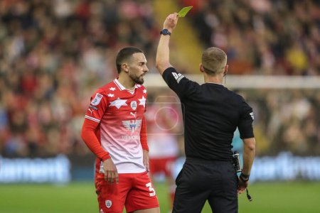 Photo for Referee Will Finnie gives a yellow card to Adam Phillips of Barnsley during the Sky Bet League 1 Sky Bet League 1 Promotion Play-offs Semi-final first leg match Barnsley vs Bolton Wanderers at Oakwell, Barnsley, United Kingdom, 3rd May 2024 - Royalty Free Image