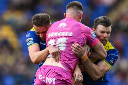Photo for Joe Burgess of Hull KR  is tackled by Lachlan Fitzgibbon of Warrington Wolves and James Harrison of Warrington Wolves during the Betfred Super League Round 11 match Warrington Wolves vs Hull KR at Warrington, United Kingdom, 9th May 2024. - Royalty Free Image